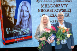 Okładka książki Na wzburzonych falach. Dwa światy w jednej rozmowie autorstwa Małgorzaty Niezabitowskiej i Feliksa Falka. Na granatowym tle umieszczono portrety autorów – Feliksa Falka oraz Małgorzaty Niezabitowskiej. Tytuł książki zapisano dużymi białymi literami w centralnej części okładki.