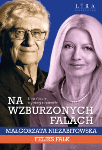 Małgorzata Niezabitowska i Feliks Falk stoją na scenie podczas spotkania promującego książkę Na wzburzonych falach, trzymając bukiety kwiatów. W tle widoczna jest okładka książki oraz napis informujący o premierze publikacji. Oboje uśmiechają się do publiczności po zakończeniu wydarzenia.