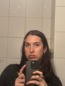 Ciemnowłosa kobieta robi sobie selfie w lustrze